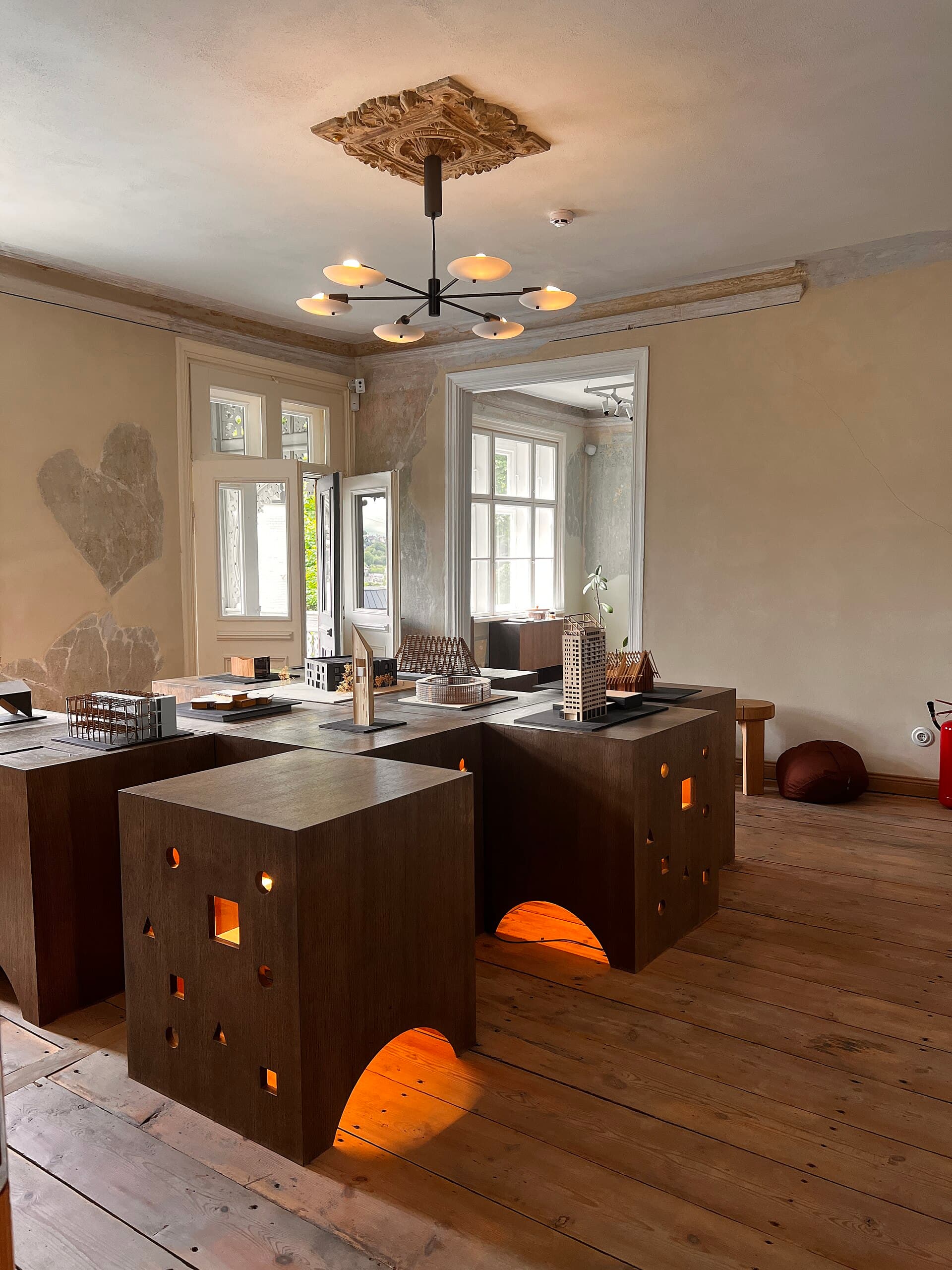 Worn wooden floor and tall windows in a converted European house.